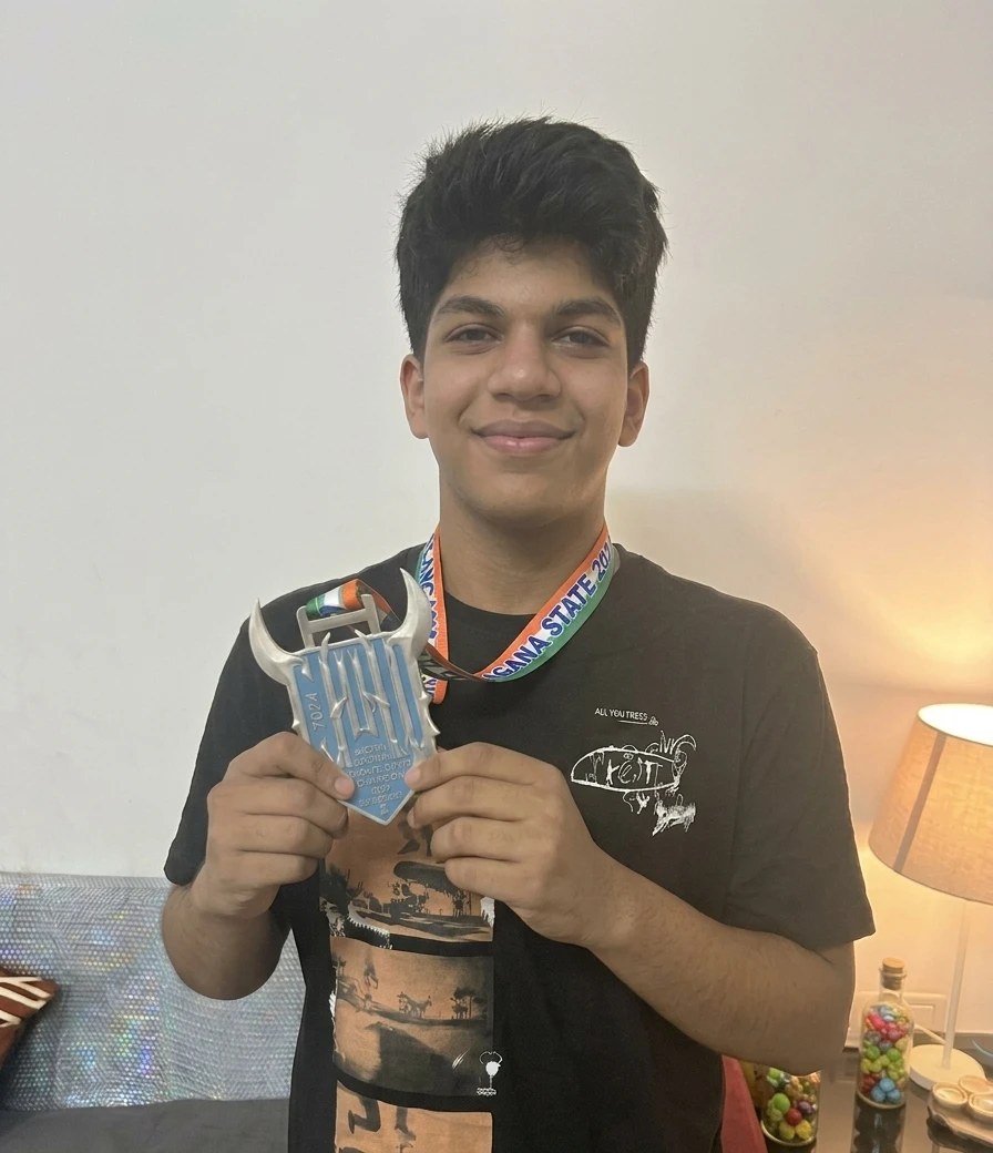 Aarav holding his WPC India national powerlifting medal